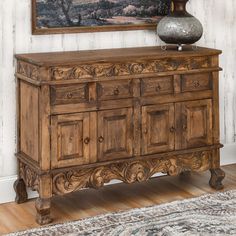 an old wooden dresser in front of a painting