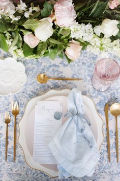 a table setting with napkins, silverware and flowers