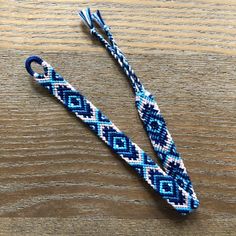 a blue and white paracording on top of a wooden table next to a pair of scissors