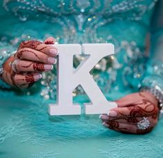 two hands holding up the letter k to show off it's hendigns