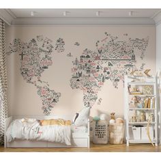 a child's bedroom with a world map wall mural in pink and grey colors