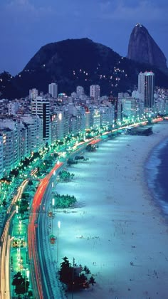 an aerial view of a beach and city at night with lights in the foreground