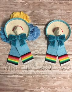 two hats and scarfs are sitting on a wooden table