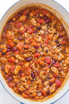 a large pot filled with chili and meats on top of a white countertop