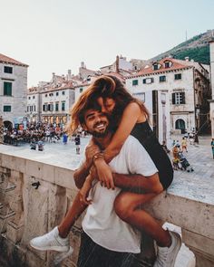 a man holding a woman on top of a bridge