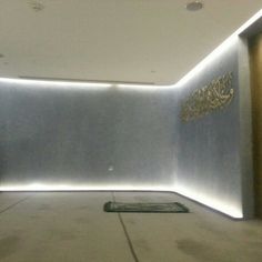 an empty room with lights on the wall and carpeted floor in front of it