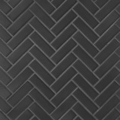 a black tile wall with an irregular pattern on the bottom and diagonal lines in the middle