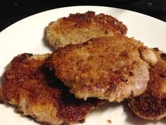 two pieces of fried meat on a white plate