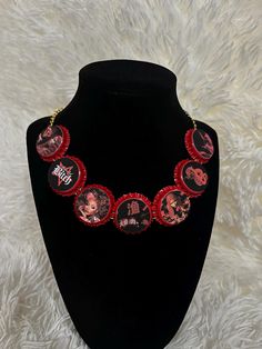 a black necklace with red and white pictures on it