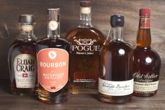 several bottles of liquor sitting on top of a wooden table