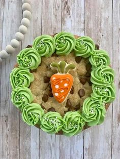 a cookie decorated with green icing and an orange carrot