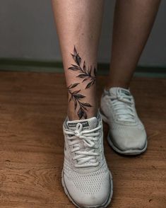 a woman's foot with a black and white flower tattoo on her left leg