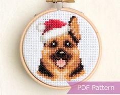 a dog with a santa hat on it's head cross stitched into a hoop