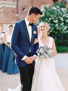 a bride and groom standing next to each other in front of a group of people