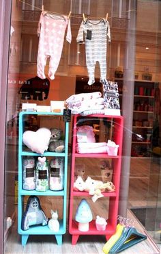 there is a display in the window of a store with baby clothes and other items