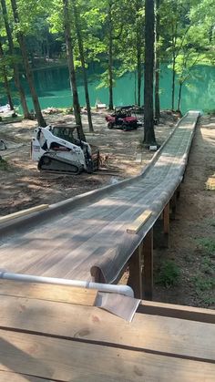 a car that is sitting on top of a wooden ramp in the middle of some trees