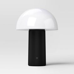 a white and black lamp sitting on top of a table