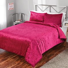 a bed with a pink comforter and pillows