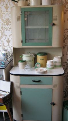 an old fashioned kitchen with green and white cabinets