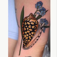 a close up of a person's arm with a tattoo on it and flowers