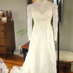 a white wedding dress on display in a room