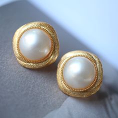 --- SPECIFICS --- 💚Materials: 100% Natural High Quality Mabe Pearl With 24k gold plated s925 Sterling silver 💚-The Mabe Pearl is 100% natural UNTREATED , UNHEATED, UNDYED Mabe Pearl- 💚Metal: Real 24k Gold plated s925 Sterling Silver 💚Pearl Diameter: 12mm*12mm 💚Closure: the closure is made of 925 Sterling Silver.  💚Handmade Artwork, original design and copyright protected💚 These stunning gold plated silver earrings feature a beautiful pair of hemisphere Mabe Pearl stones. With their intric Fake Mabe Pearl Earrings, Classic White Gold Clip-on Earrings For Formal Occasions, Classic Bridal Earrings With Elegant Design For Evening, Classic Elegant Design Bridal Earrings For Evening, Classic Elegant Bridal Earrings For Evening, Classic White Gold Clip-on Earrings For Anniversary, Classic Clip-on Bridal Earrings For Evening, Elegant Formal Clip-on Earrings, Classic Evening Bridal Clip-on Earrings