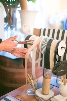 a person cutting ribbon on top of a chair with scissors and other items around it