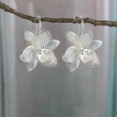 These flower earrings are just that right balance between literal and abstract. A gentle satin finish gives them added shimmer and they balance perfectly on the long ear wire hook.  Size: 25 X 30 mm (drop)  All of my jewellery comes wrapped in tissue paper and packed in a pretty gift Blossom Flower-shaped Earrings For Wedding, Blossom Flower Earrings For Wedding, Blossom Colored Flower Earrings For Wedding, Elegant Blossom Flower Earrings, Silver Dangle Flower Earrings For Spring, Elegant Floral Drop Earrings, Elegant Blossom-colored Drop Flower Earrings, Elegant Blossom Color Flower Drop Earrings, Handmade Flower-shaped Silver Jewelry