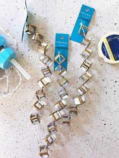 several pieces of jewelry sitting on top of a table next to a pair of scissors