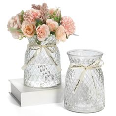 two glass vases with flowers in them