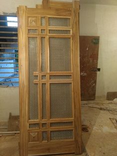 a large wooden cabinet sitting inside of a room next to a window with blinds on it