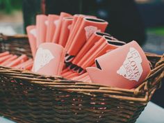 a basket filled with pink paper cups sitting on top of a table