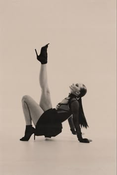 a black and white photo of a woman on the ground with her legs spread out