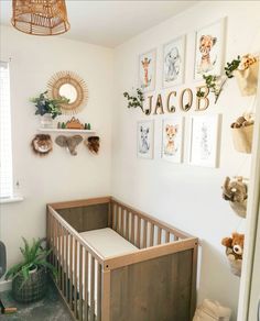 a baby's room with pictures on the wall and a crib in the corner