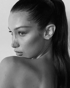 a black and white photo of a woman's face with her hair in a ponytail