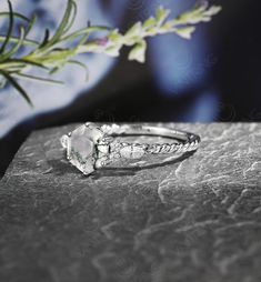 a white diamond ring sitting on top of a rock