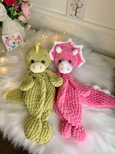 two crocheted teddy bears sitting next to each other on a white fur rug