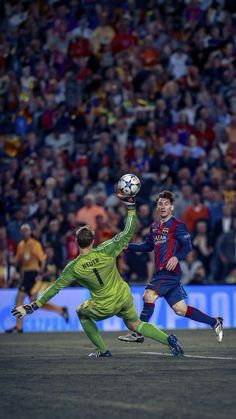 two men are playing soccer in front of an arena full of people, one is reaching for the ball