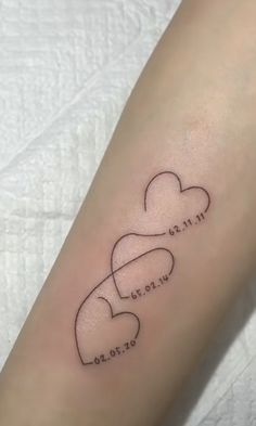 a small tattoo on the arm of a woman's left arm with an intertwined heart