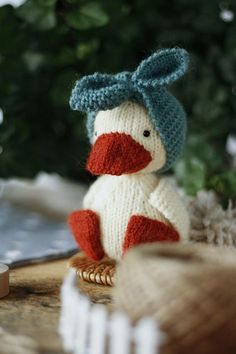 a knitted duck sitting on top of a wooden table