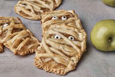 apple pies with eyes and googly eyes are on the table next to an apple