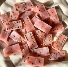 pink dices with gold rivets on them sitting on a white cloth covered tablecloth