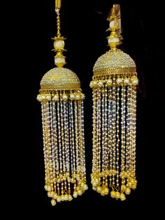 two golden chandeliers with beads hanging from them