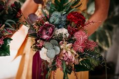 a woman holding a bouquet of flowers in her hands