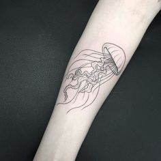 a black and white photo of a jellyfish tattoo on the left forearm, with lines drawn across it