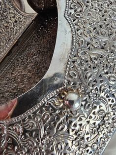 an intricately designed metal table with silverware on it's sides and handles