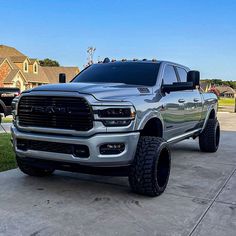 a large silver truck parked on top of a driveway