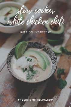 a bowl filled with chicken and avocado on top of a wooden table