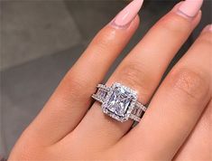 a woman's hand with a ring on it and an engagement ring in the middle