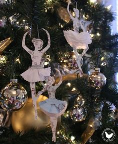 an ornament hanging from the christmas tree in front of a ballerina figure